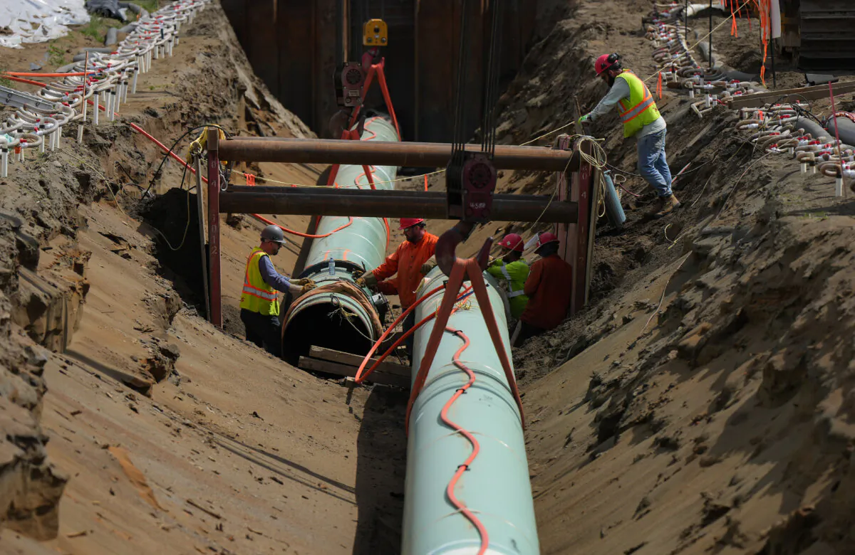 Workers lay pipe during construction of the Trans Mountain pipeline in Abbotsford, B.C., on May 3, 2023. (The Canadian Press/Darryl Dyck)