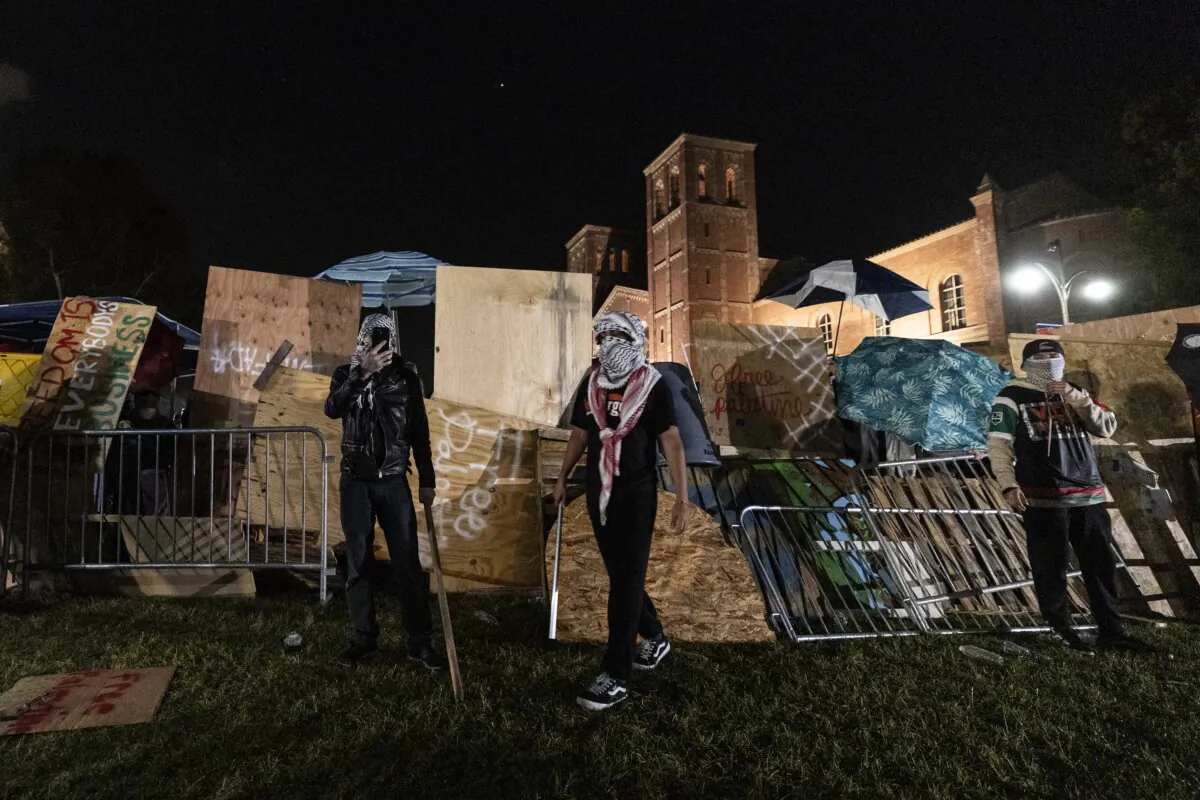 Pro-Palestinian demonstrators rebuild the barricade surrounding their encampment at UCLA after clashes with counter-protesters in Los Angeles on May 1, 2024. (Etienne Laurent/AFP via Getty Images)