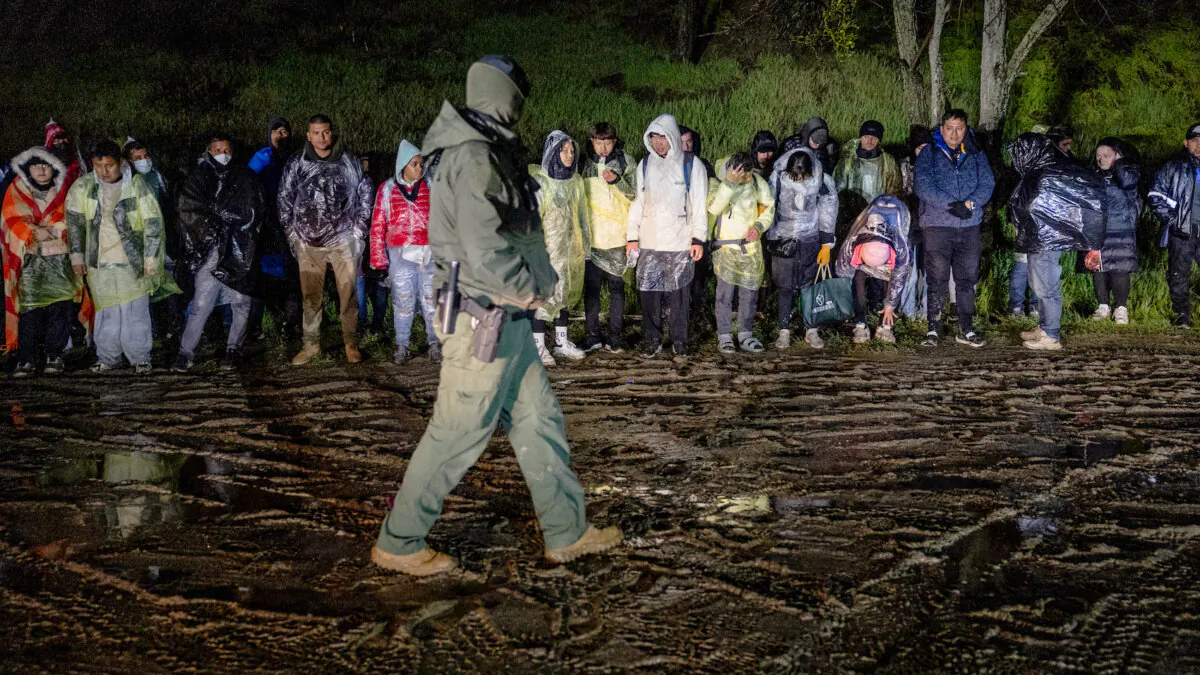 A U.S. Border Patrol agent counts immigrants before transporting them for further processing in Campo, Calif., on March 7, 2024. They were part of a group of immigrants delivered by Mexican smugglers to a remote area of the U.S.-Mexico border to cross and request political asylum in the United States. (John Moore/Getty Images)
