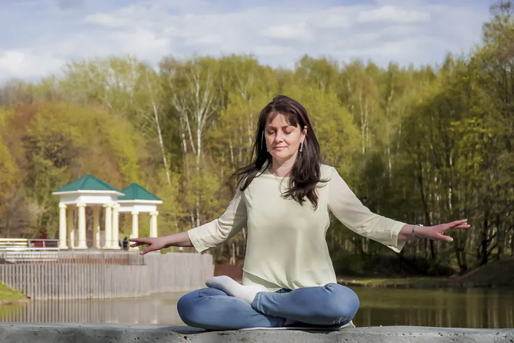 Natalya Minenkova does the Falun Gong meditation in Dendropark in Moscow, Russia, on July 5, 2022. (The Epoch Times)