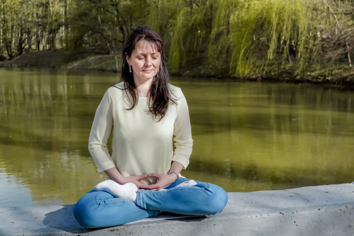 Natalya Minenkova does Falun Gong meditation in Dendropark in Moscow on July 5, 2022. (The Epoch Times)