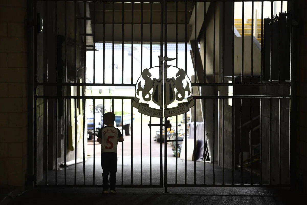 A Newcastle United fan looks through the gates onto the pitch at the club's stadium St James' Park in Newcastle in England on Oct. 8, 2021. (Oli Scarff/AFP via Getty Images)