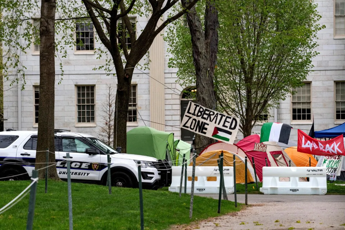 A police cruiser sits by tents and signs that fill Harvard Yard by the John Harvard statue in the Pro-Palestinian encampment at Harvard University in Cambridge, Mass., on May 5, 2024. (Joseph Prezioso/AFP via Getty Images)