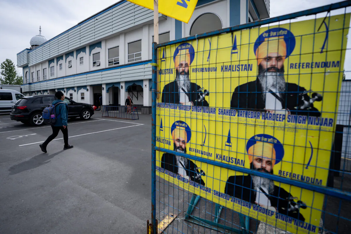 A person walks past signs of Hardeep Singh Nijjar at the Guru Nanak Sikh Gurdwara in Surrey, B.C. on May 3, 2024. (The Canadian Press/Ethan Cairns)