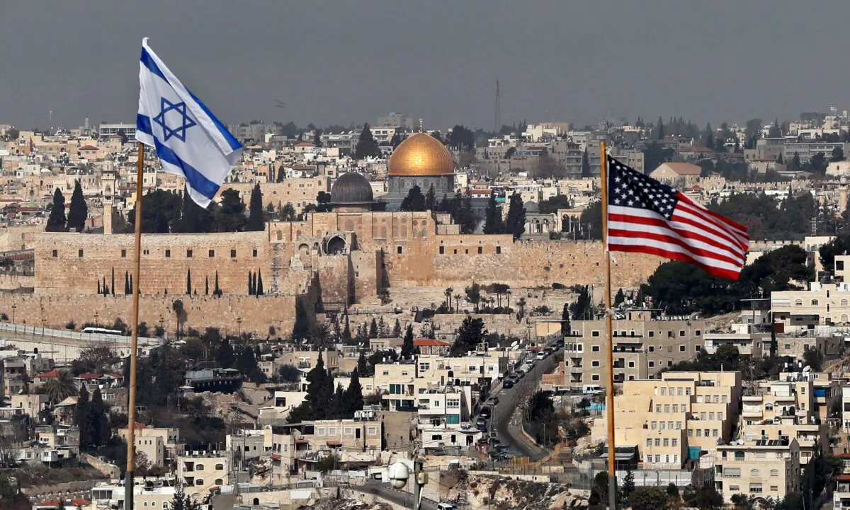 TOPSHOT - A picture taken on December 13, 2017, shows the Israeli and US flags placed on the roof of an Israeli settlement building in East Jerusalem and Jerusalem's Old City with the Dome of the Rock mosque in the centre. (Photo by AHMAD GHARABLI / AFP) (Photo by AHMAD GHARABLI/AFP via Getty Images)
