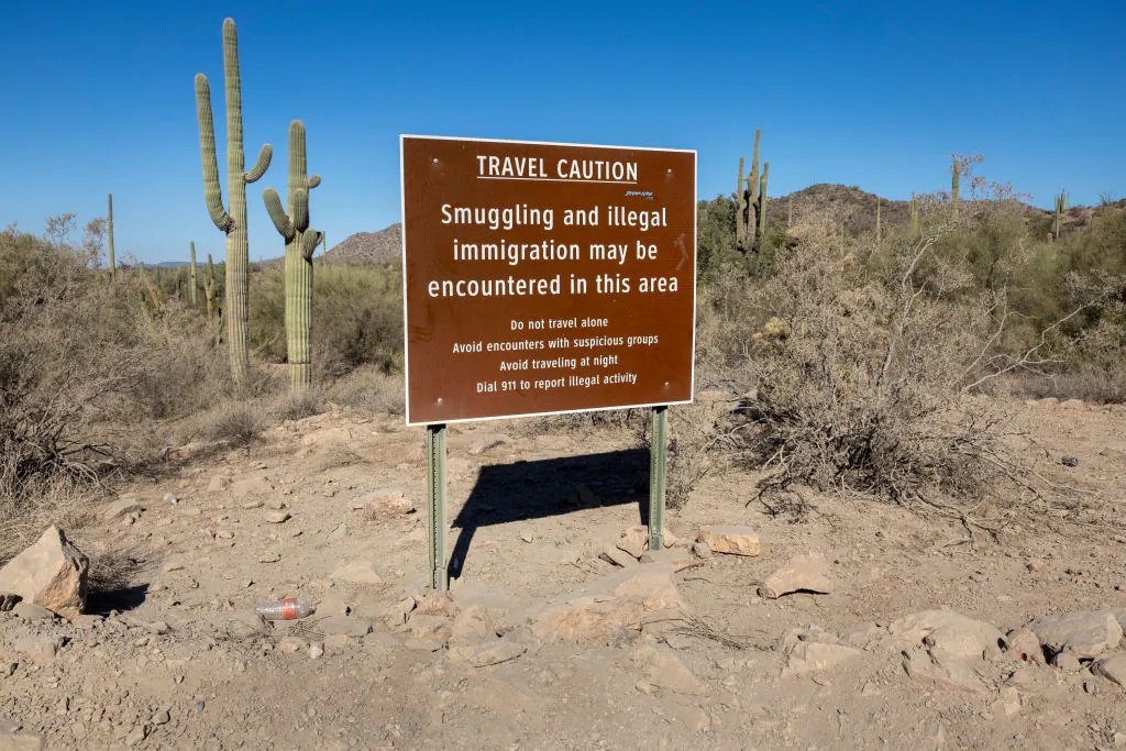 A sign warning of smuggling and illegal immigration stands in the Organ Pipe Cactus National Monument near U.S.-Mexico border in Lukeville, Arizona, on December 08, 2023. (John Moore/Getty Images)