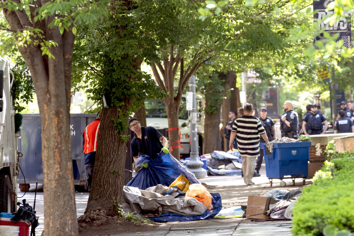 Workers carry student tents to a dump truck after police cleared a pro-Palestinian tent encampment at George Washington University early on May 8 and arrested demonstrators in Washington on May 8, 2024. (Jose Luis Magana/AP Photo)