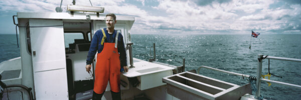 KILKEEL, NORTHERN IRELAND - AUGUST 11: (EDITORS NOTE: This image was taken using a panoramic film camera) Fisherman Brian Cunningham is photographed on board his boat 'The Bluefin' out in the Irish Sea on August 11, 2018 in Kilkeel, Northern Ireland. Kilkeel houses Ireland's largest fishing fleet. Cunningham says "My biggest fear is displacement of fishing effort. We traditionally fished in the bay of Dundalk a few miles along the coast but we'll no longer be allowed in there, it's a disaster for the inshore fishing fleet. There are 40 small boats in Kilkeel harbour who seek shelter through the winter from the prevailing south west winds, when Brexit happens where will they go? Small boats exposed 12 miles out to sea, that's life or death stuff and that's not bullshit, that's reality!". Following the United Kingdom European Union Membership Referendum in 2016, 51.9 per cent of British people voted to leave the European Union (EU). People in Northern Ireland voted to remain by a majority of 56 per cent to 44 per cent. The EU Withdrawal Act of 2018 has declared that the UK will exit the union on the 29th of March 2019. The frontier between Northern Ireland and the Republic of Ireland runs for 310 miles and is the only border between the UK and the EU. During the Northern Ireland conflict of the latter 20th century the border was controlled by police and soldiers and known as a "Hard Border"- it is a return this situation after Brexit that the people of both countries fear. (Photo by Charles McQuillan/Getty Images)