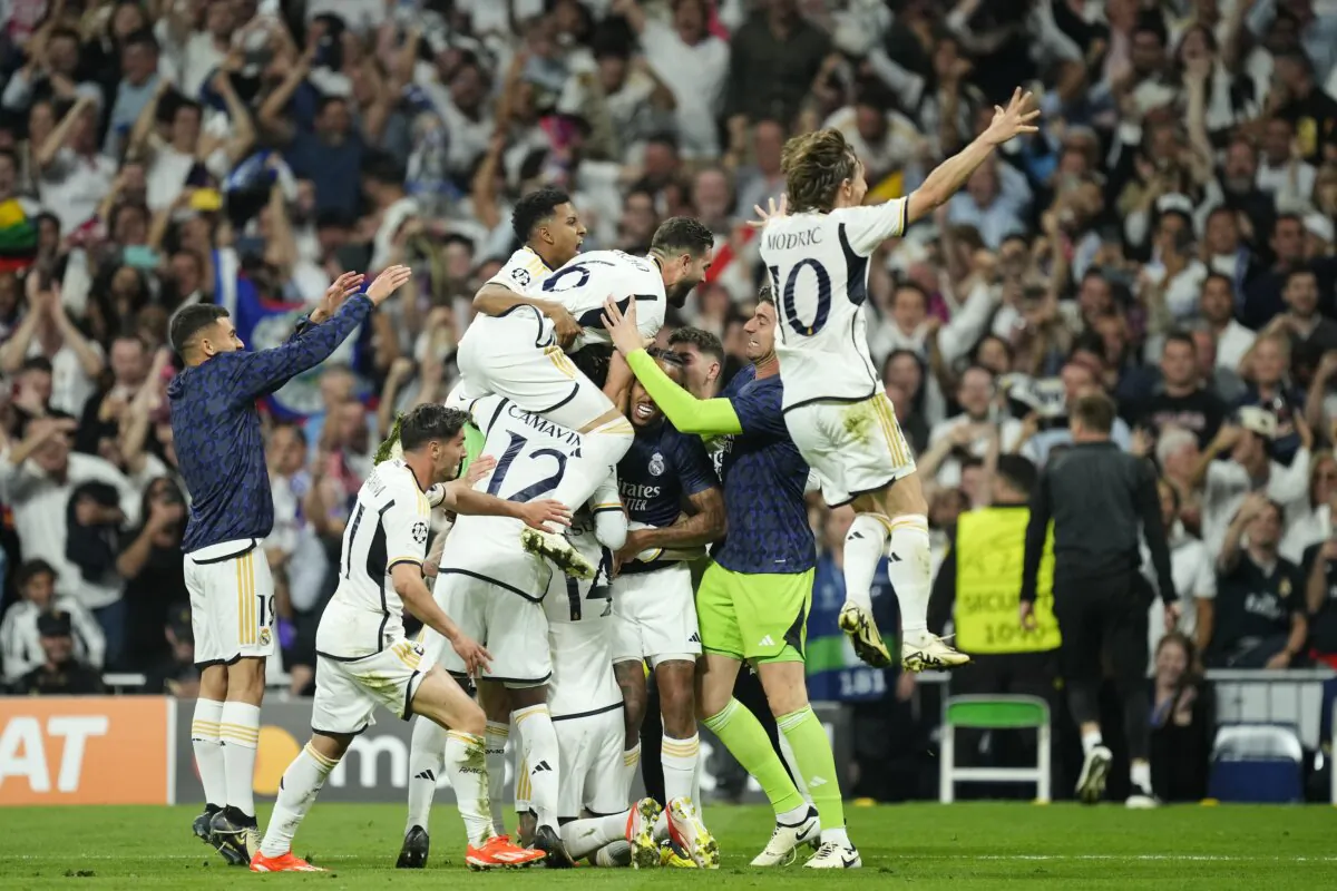 Real Madrid's Joselu, covered by his teammates, celebrates after scoring his side's second goal during the Champions League semifinal second leg soccer match between Real Madrid and Bayern Munich at the Santiago Bernabeu stadium in Madrid on May 8, 2024. (Jose Breton/AP Photo)