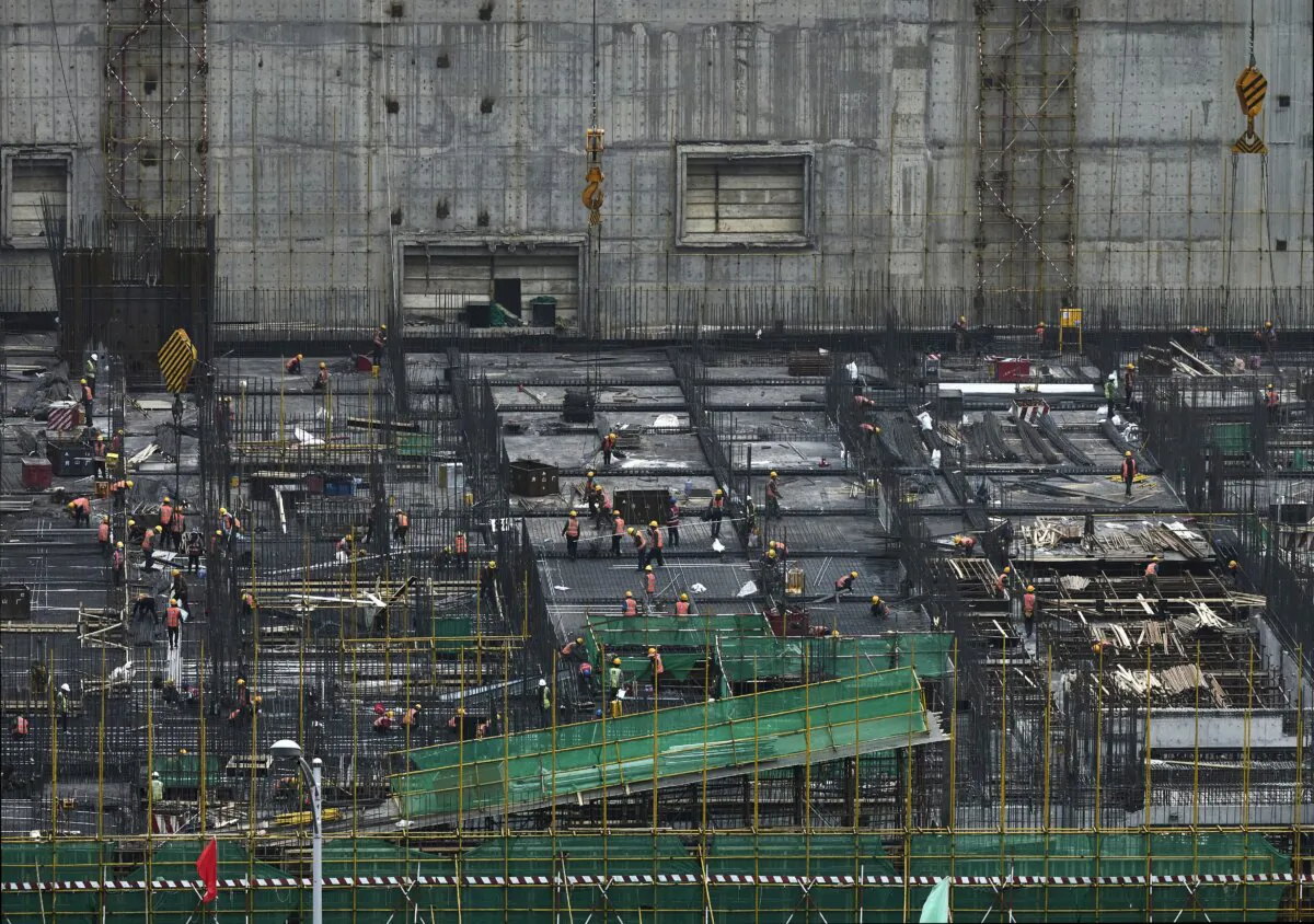 Construction workers work at a large building site in the Central Business District in Beijing on April 13, 2023. (Kevin Frayer/Getty Images)