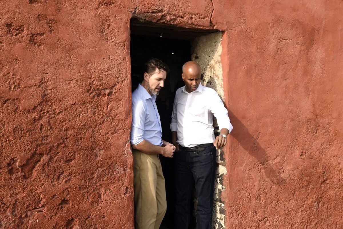 Prime Minister Justin Trudeau talks with cabinet minister Ahmed Hussen at the “Door of the Journey of No Return” at the Goree Slave House in Senegal, where Canada announced new aid measures, on Feb. 12, 2020. (Seyllou/AFP via Getty Images)