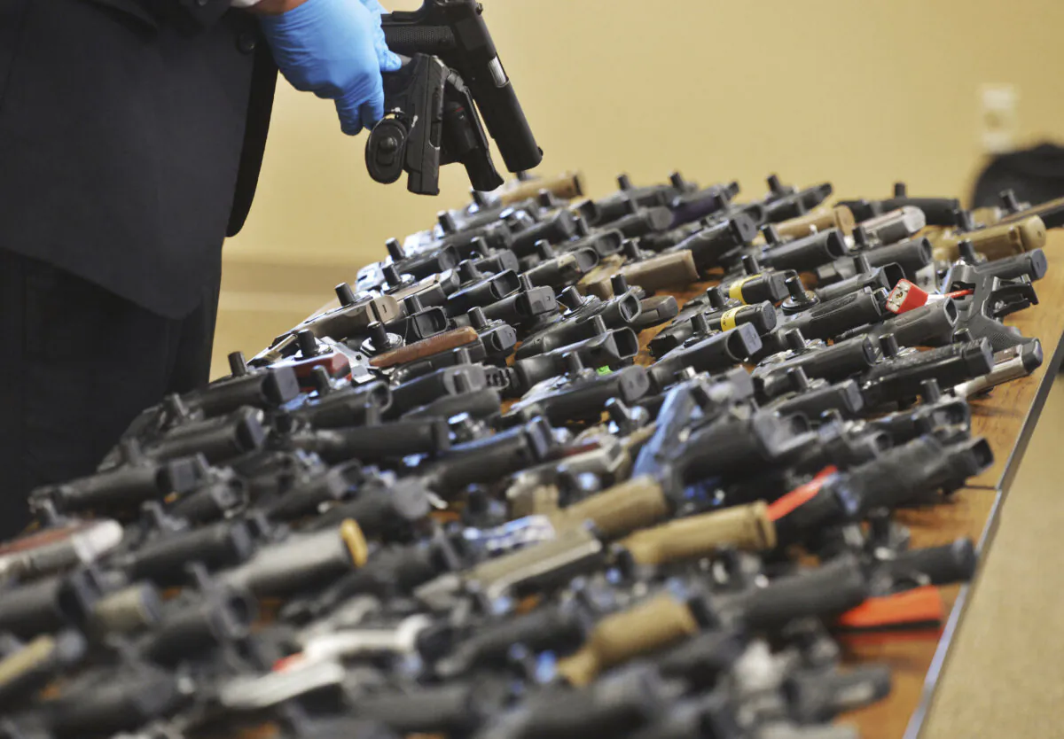 Dozens of recovered stolen handguns are displayed during a press conference in Benton Township, Mich., Nov. 21, 2023. (Don Campbell/The Herald-Palladium via AP)