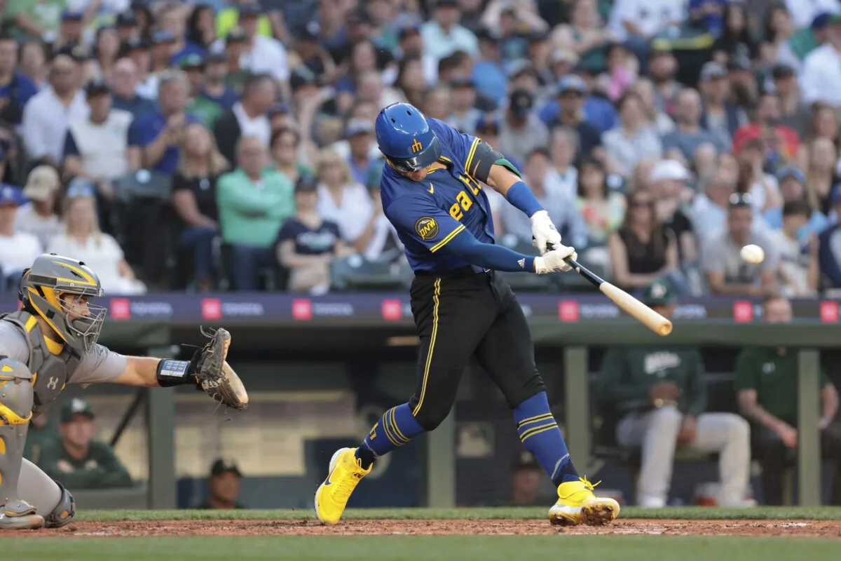 Seattle Mariners' Dylan Moore, right, hits a home run as Oakland Athletics catcher Shea Langeliers (L) looks on during the fourth inning of a baseball game in Seattle on May 10, 2024. (Jason Redmond/AP Photo)
