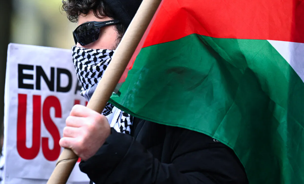 A pro-Palestinian protester carries a Palestinian flag outside the Columbia University campus in New York City on April 24, 2024. (Timothy Clary/AFP)