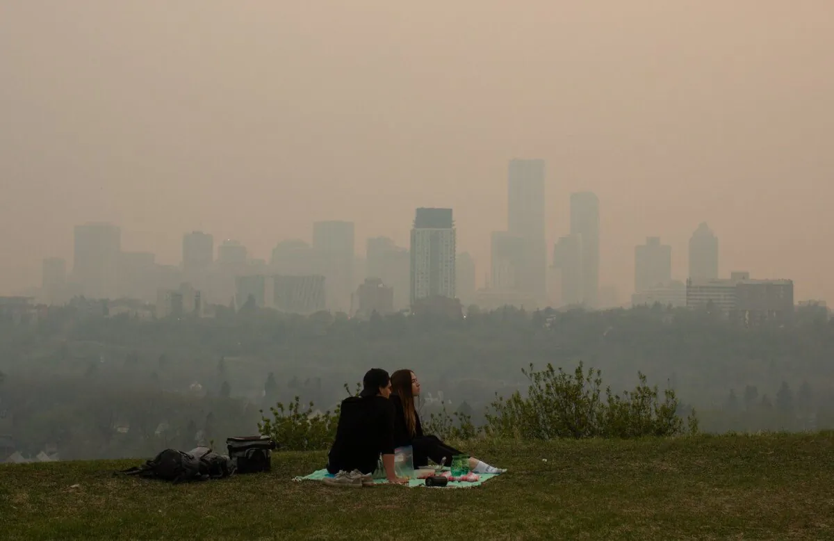 Smoke from wildfires blankets the city as a couple has a picnic in Edmonton, May 11, 2024. (The Canadian Press/Jason Franson)
