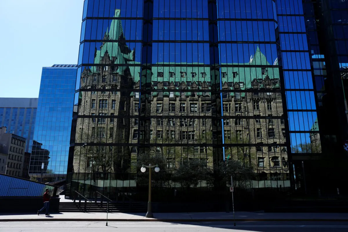 The Confederation Building on Parliament Hill is reflected in the windows of the Bank of Canada, in Ottawa on May 6, 2024. (The Canadian Press/Sean Kilpatrick) 