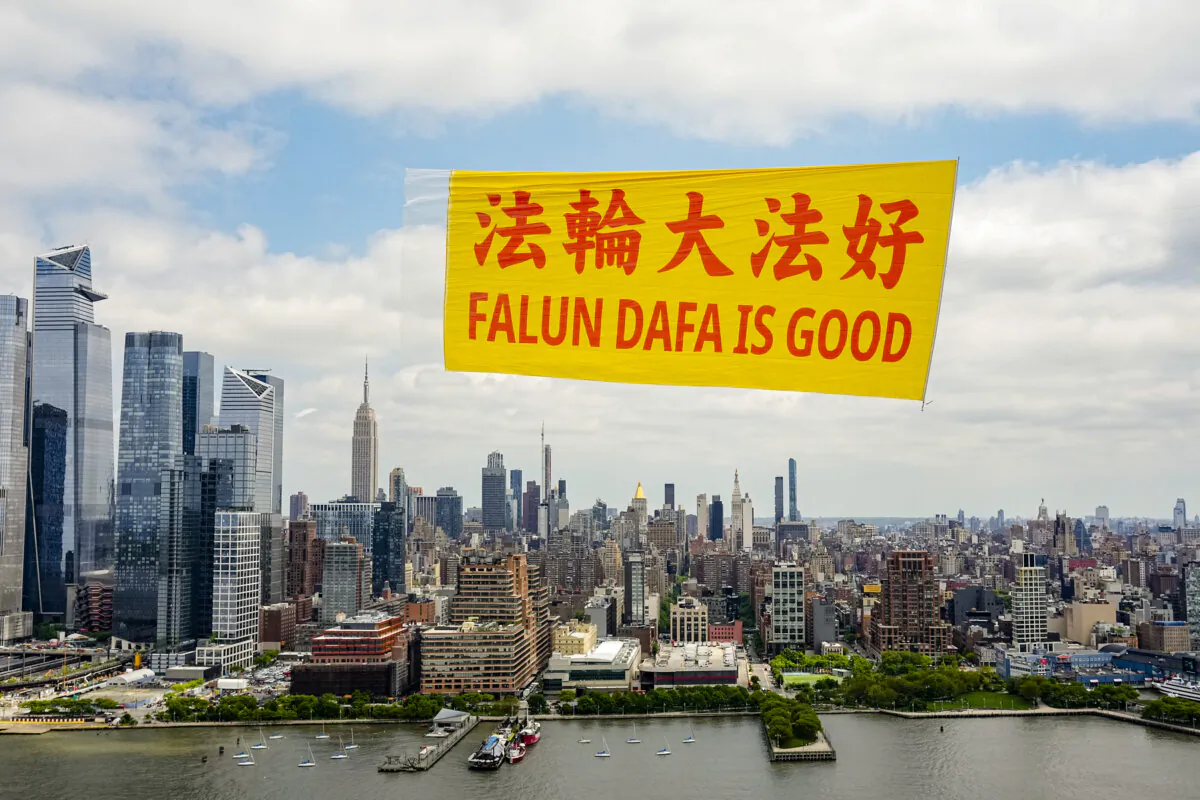 A banner reading “Falun Dafa Is Good” flies over the Hudson River in New York, on May 13, 2024. (Larry Dye/The Epoch Times)