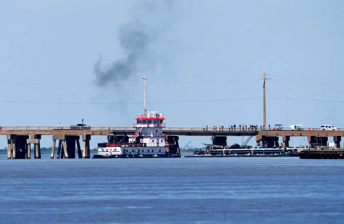 A tugboat works to maneuver a barge away from the Pelican Island Bridge in Galveston, Texas, after the barge crashed into the bridge, shutting down the only road access to and from the island, on May 15, 2024, . (Jennifer Reynolds/The Galveston County Daily News via AP)