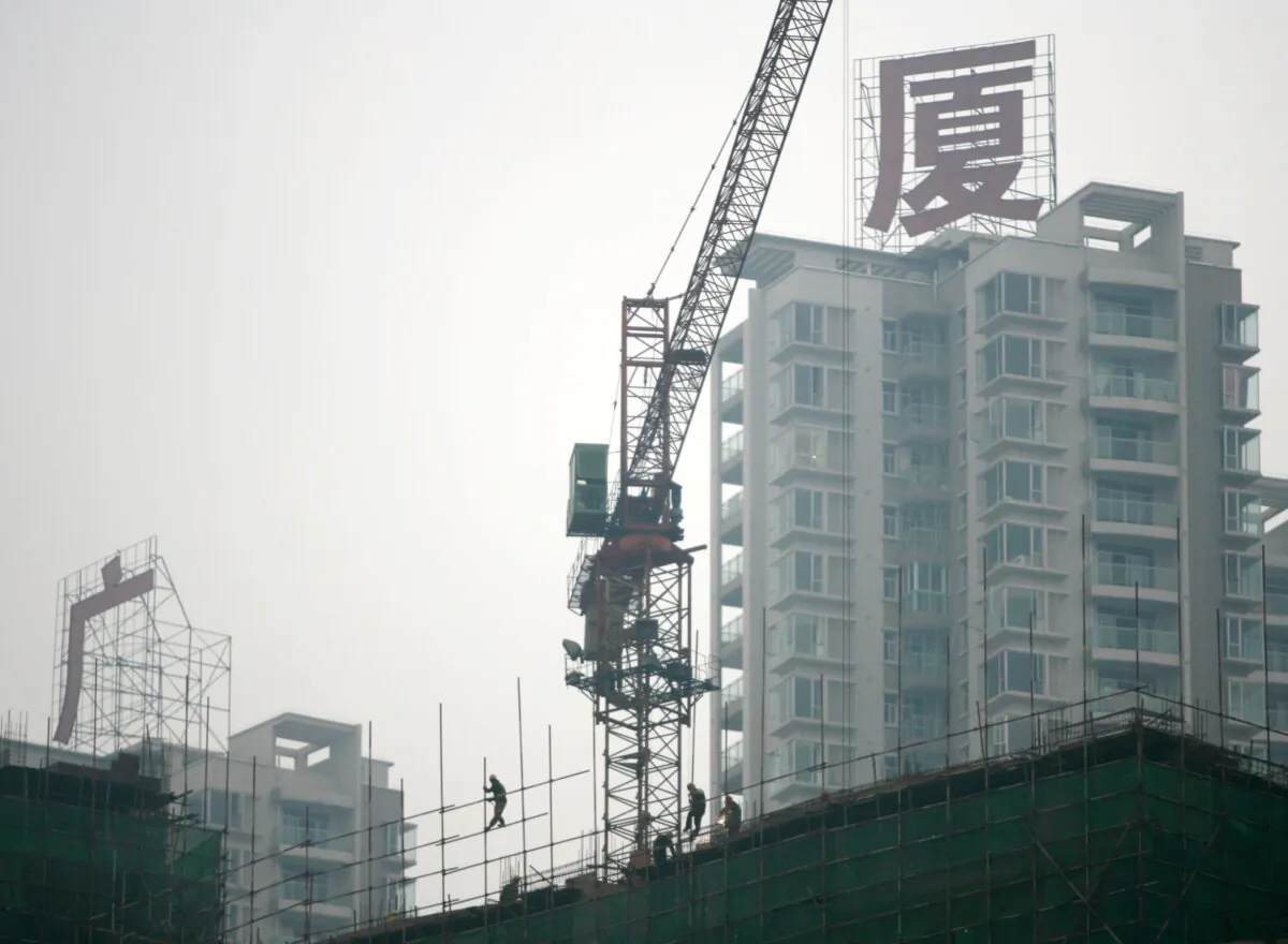 A migrant worker erects scaffoldings at a construction site on January 13, 2007 in Chongqing Municipality, China. (China Photos/Getty Images)