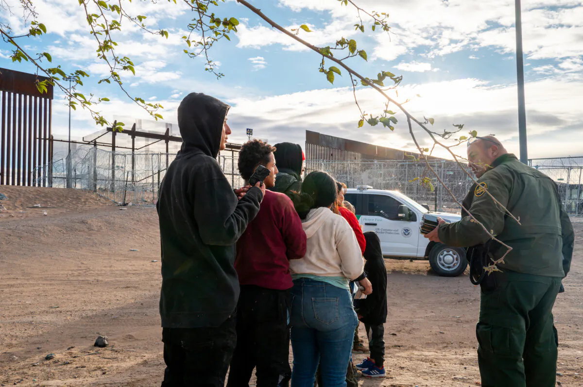 A group of migrants wait to be processed after crossing the Rio Grande in El Paso, Texas, on April 2, 2024. (Brandon Bell/Getty Images)