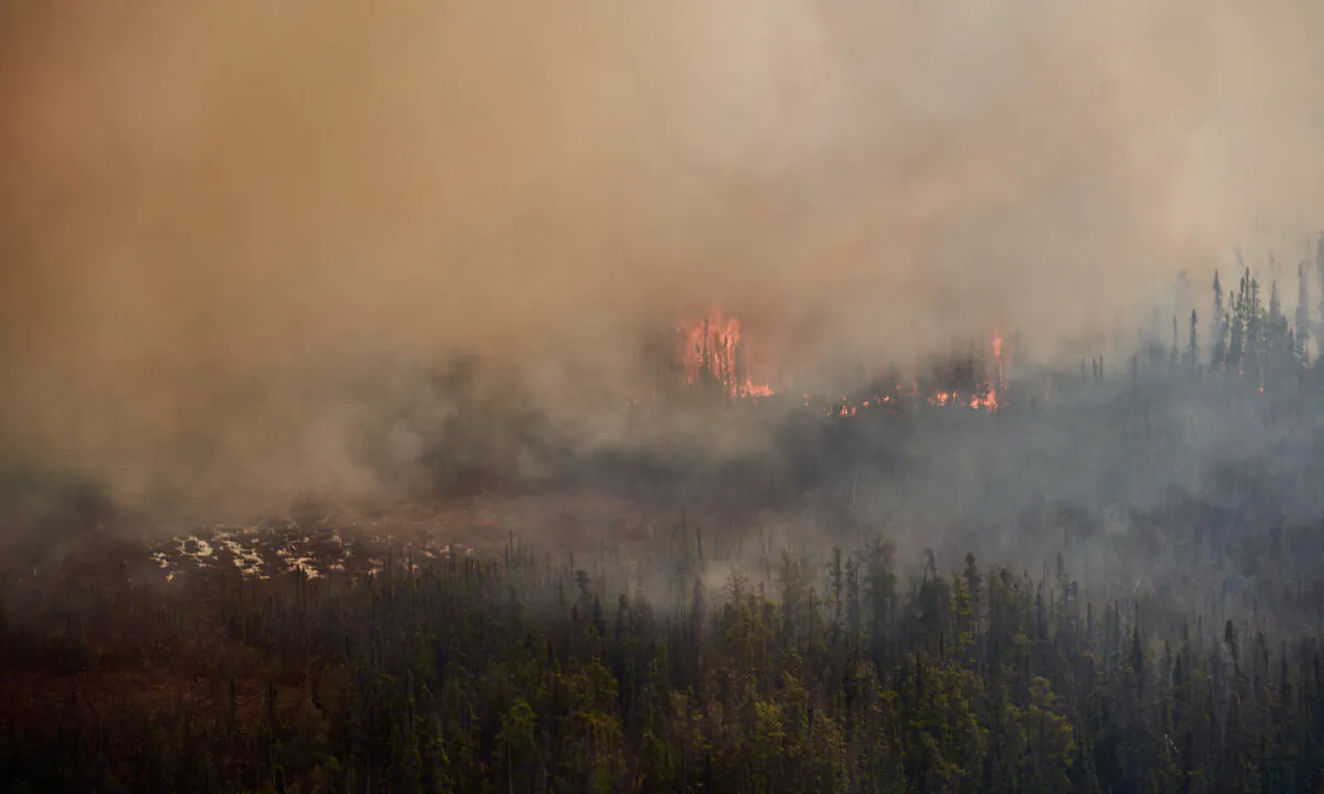 A wildfire burns near Flin Flon, on the Manitoba-Saskatchewan border, as seen from a helicopter surveying the situation on May 14, 2024. (The Canadian Press/David Lipnowski)