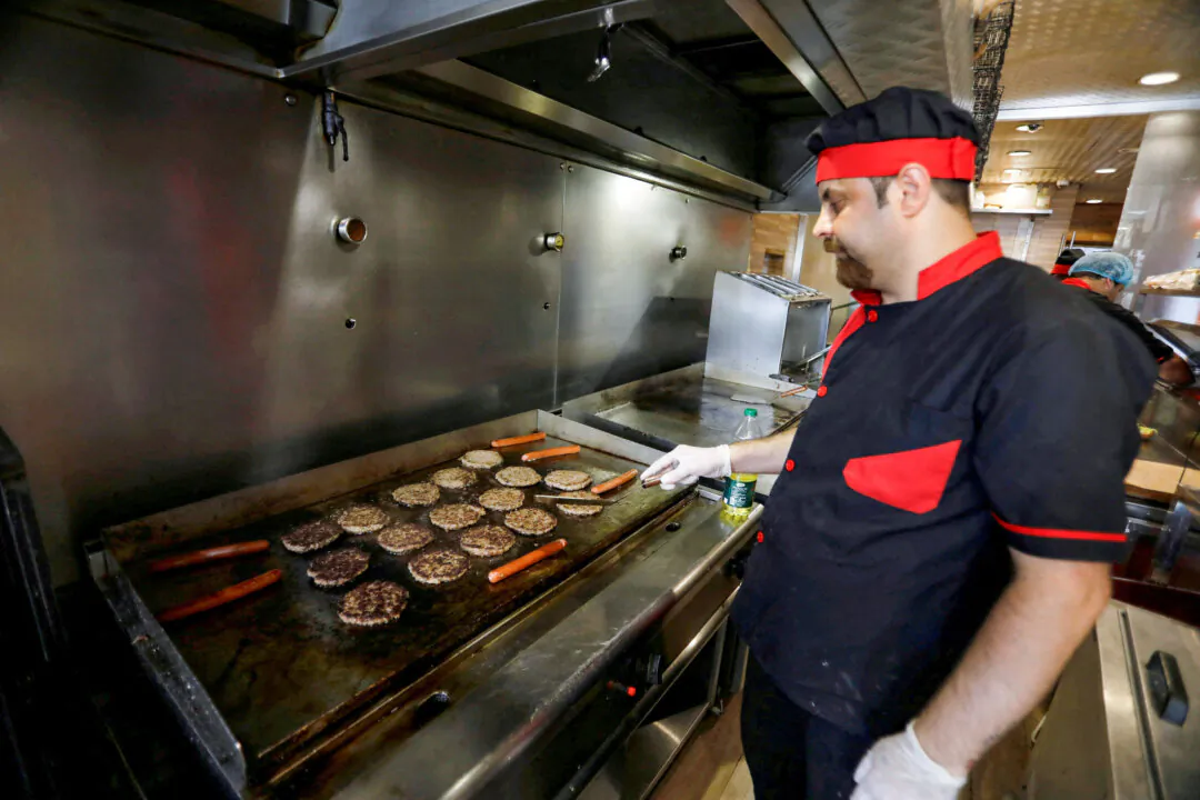 Burgers are cooked on a grill at a restaurant in Baghdad, Iraq, on June 25, 2019. (Khalid al-Mousily/Reuters)