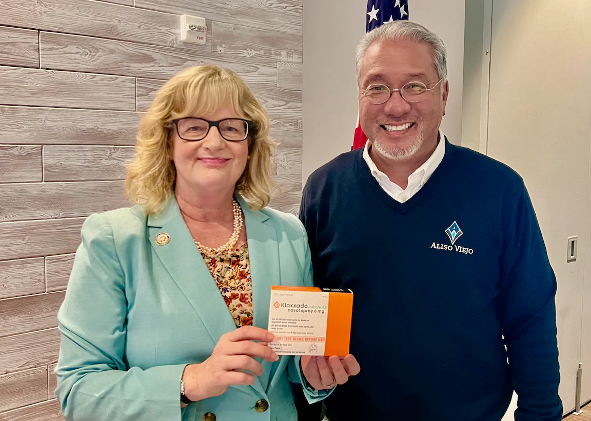 Orange County Supervisor Katrina Foley holds naloxone next to Aliso Viejo Councilman Ross Chun in Aliso Viejo, Calif., on May 16, 2024. (Rudy Blalock/The Epoch Times)