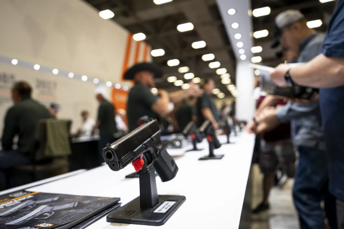 People try out firearms at the National Rifle Association (NRA) exhibits at the Kay Bailey Hutchison Convention Center in Dallas, Texas, on May 18, 2024. (Madalina Vasiliu/The Epoch Times)