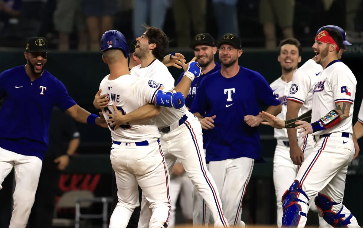 Nathaniel Lowe (30) of the Texas Rangers celebrates with teammate Josh Smith (8) after Lowe was hit by a pitch with the bases loaded to win the game against the Los Angeles Angels in the thirteenth inning in Arlington, Texas, on May 18, 2024. (Ron Jenkins/Getty Images)