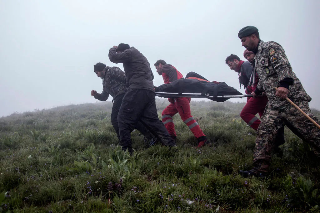 A response team recovers bodies at the crash site of a helicopter transporting Iran's president, his foreign minister, and others in a fog-covered mountainous area of Varzaghan in northwestern Iran on May 20, 2024.(Azin Haghighi/MOJ News Agency/AFP via Getty Images)
