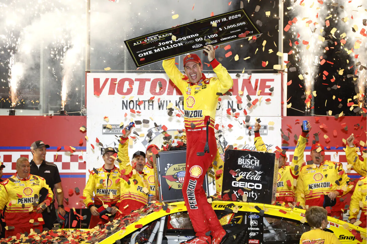 Joey Logano, driver of the (22) Shell Pennzoil Ford, celebrates with the one million dollar check in victory lane after winning the NASCAR Cup Series All-Star Race at North Wilkesboro Speedway in North Wilkesboro, North Carolina on May 19, 2024. (Sean Gardner/Getty Images)
