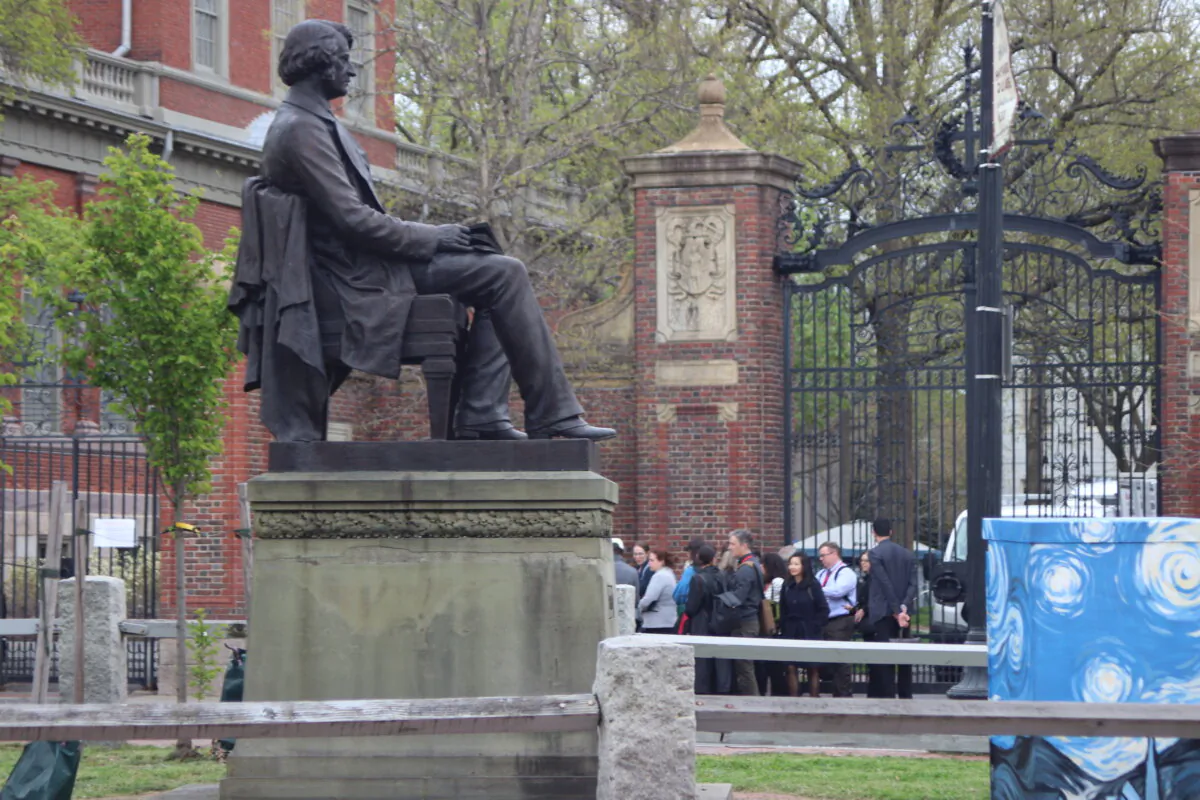 A Harvard University tour group outside closed gates at the university on April 29, 2024. (Alice Giordano/Epoch Times)