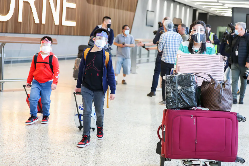 A family traveling on SQ237 walk through Melbourne Airport International arrivals hall on November 01, 2021 in Melbourne, Australia. Fully vaccinated international travellers arriving in Victoria from Monday 1 November were no longer required to enter mandatory hotel quarantine, following the easing of state and federal COVID-19 border rules. Australian citizens were also able to leave the country without requiring a travel exemption. (Photo by Asanka Ratnayake/Getty Images)
