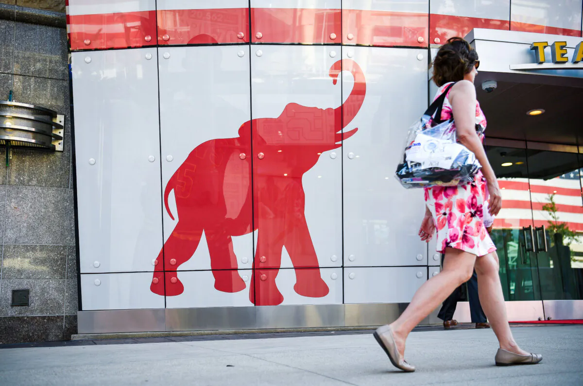 A woman walks past the logo of the Republican Party on the first day of the Republican National Convention in Cleveland, Ohio, on July 18, 2016. (DOMINICK REUTER/AFP via Getty Images)