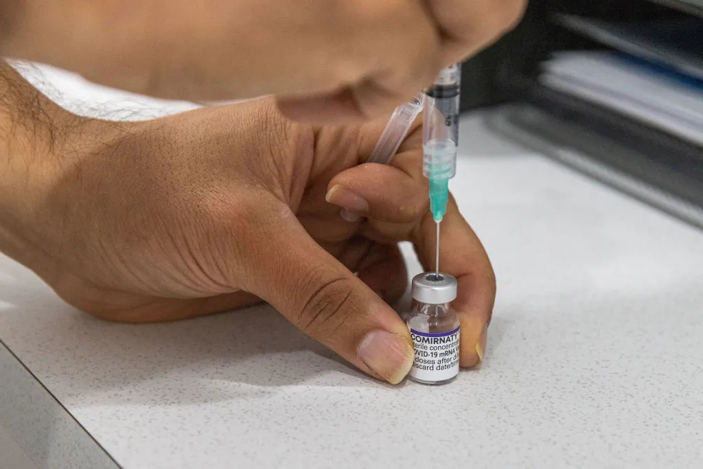 A pharmacist is seen preparing a Covid-19 vaccine at the Pharmacy 4 Less M-City Clayton on July 11, 2022 in Melbourne, Australia. (Photo by Asanka Ratnayake/Getty Images)