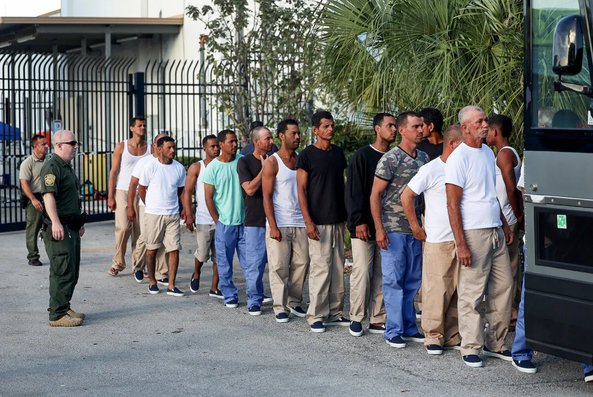 Illegal aliens from Cuba line up to board a bus to be driven to a U.S. Customs and Border Protection station as they are processed in Marathon, Fla., on Jan. 5, 2023. (Joe Raedle/Getty Images)