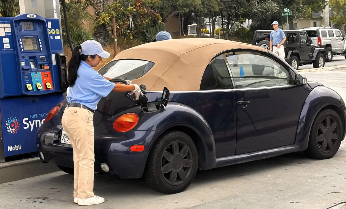 A helper with the SoCal Helpful Honda Dealers fills the gas tank for veteran M.J. Barnett of Burbank at the Mobil Burbank Gas & Mart station on North Glenoaks Boulevard on May 23, 2024. (Jill McLaughlin/The Epoch Times)