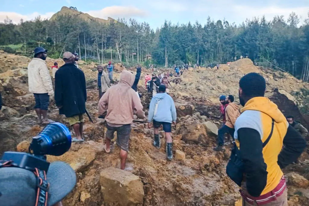 People gather at the site of a landslide in Maip Mulitaka in Papua New Guinea's Enga Province on May 24, 2024. Local officials and aid groups said a massive landslide struck a village in Papua New Guinea's highlands on May 24, with many feared dead. (STR/AFP via Getty Images)