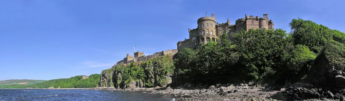 A coastal view of Culzean Castle showcases a blend of medieval, Georgian, and Gothic Revival architecture, surrounded by picturesque gardens and parkland designed to complement its dramatic clifftop setting. (digicia/CC BY 2.0)