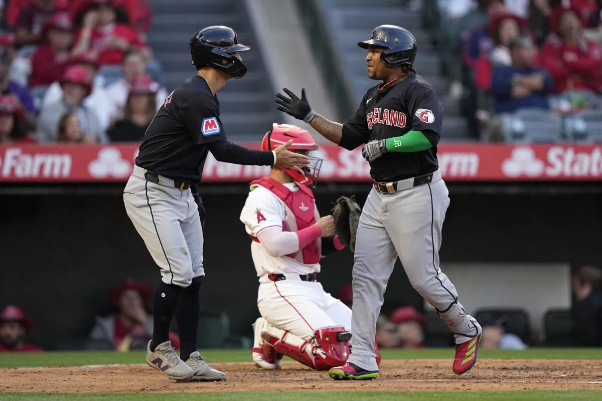 Cleveland Guardians' Jose Ramirez (R) is congratulated by Andres Gimenez after hitting a two-run home run as Los Angeles Angels catcher Logan O'Hoppe kneels at the plate during the third inning of a baseball game in Anaheim, Calif., on May 24, 2024. (Mark J. Terrill/AP Photo)