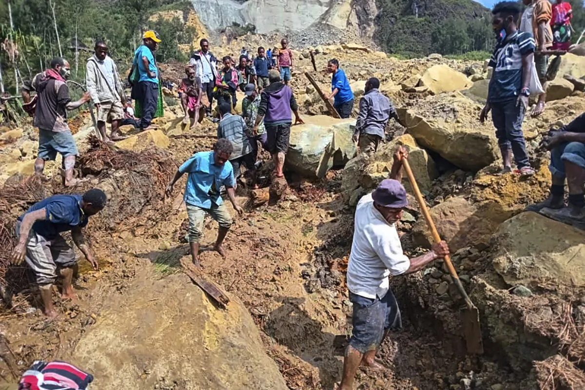 Villagers search through a landslide in Yambali, in the Highlands of Papua New Guinea, on May 26, 2024. (Mohamud Omer/International Organization for Migration via AP)