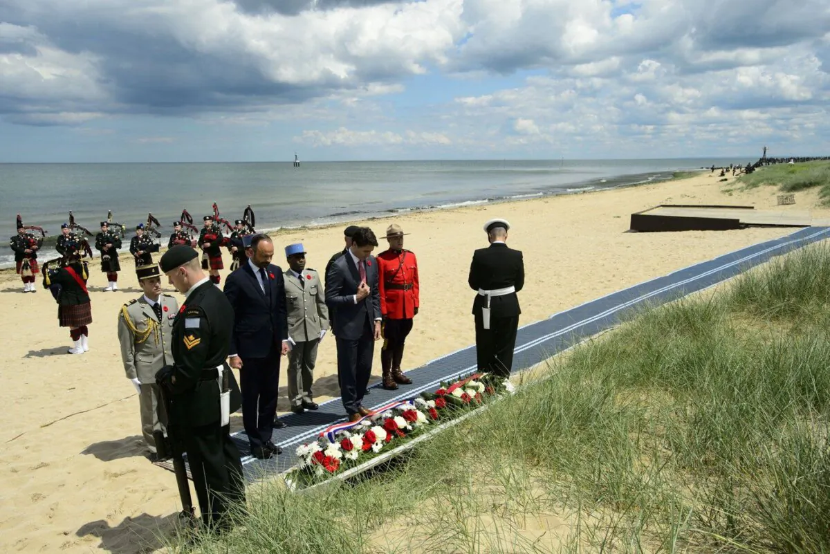 Trudeau and the Prime Minister of France Edouard Philippe take part in a wreath laying as part of the D-Day 75th Anniversary Canadian National Commemorative Ceremony at Juno Beach in Courseulles-sur-Mer, France, June 6, 2019. (The Canadian Press/Sean Kilpatrick)