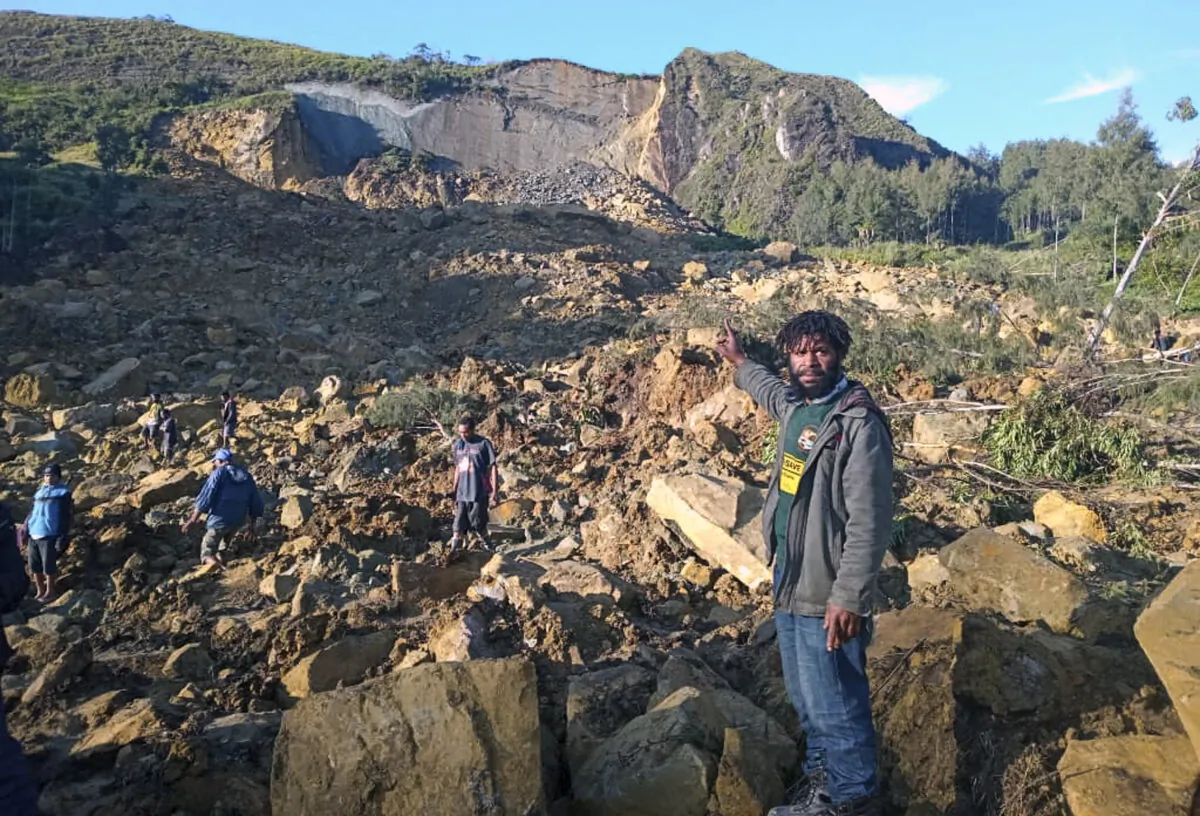 People gather at the site of a landslide in Maip Mulitaka in Papua New Guinea's Enga Province on May 24, 2024. (STR/AFP via Getty Images)