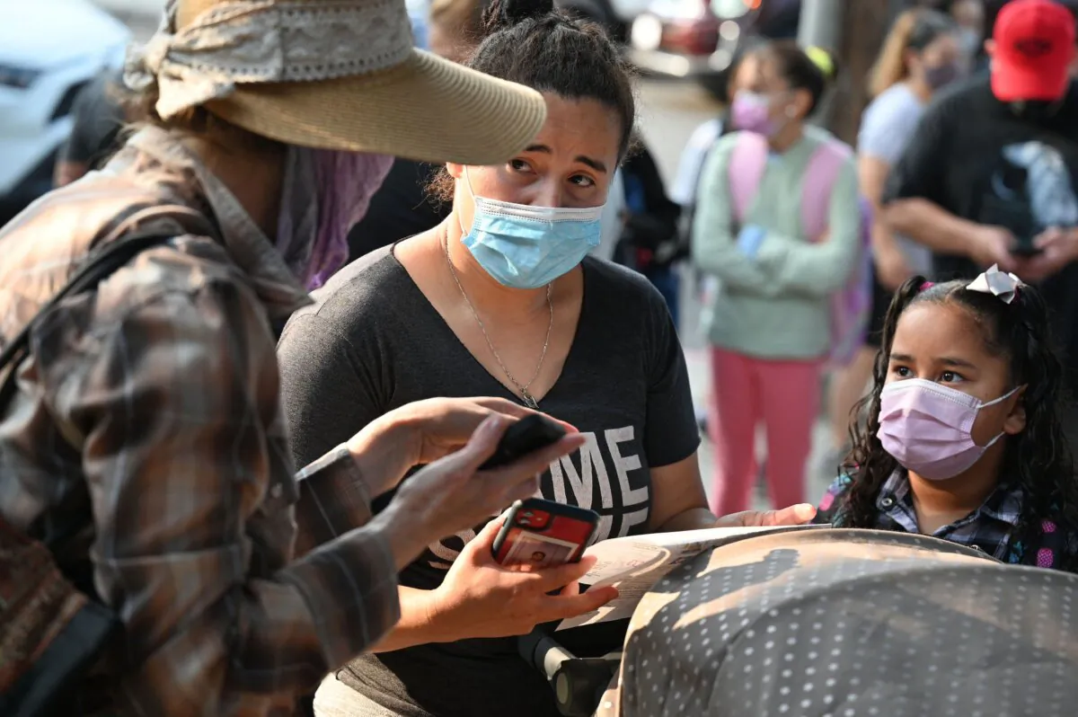 A volunteer (L) talks to a parent on the first day of the school year at Grant Elementary School in Los Angeles, in this file photo. (Robyn Beck/AFP via Getty Images)