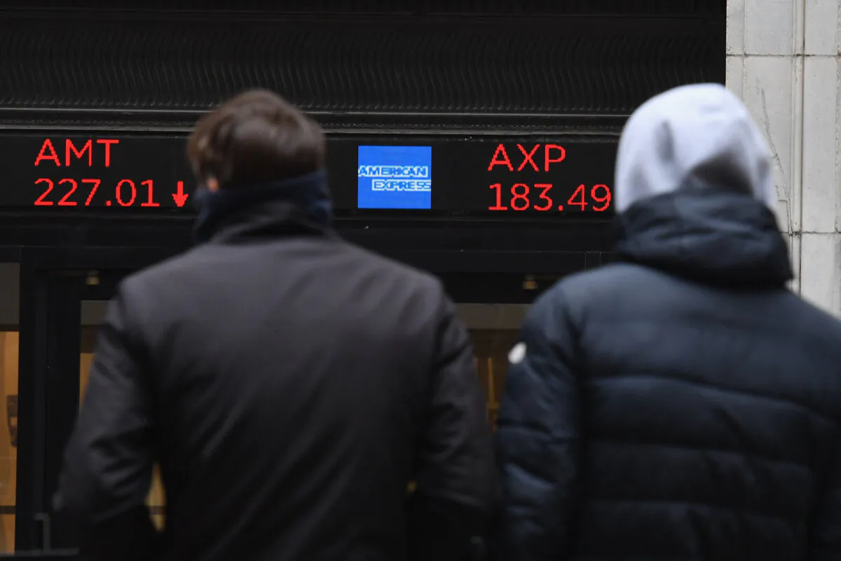People look at stocks displayed at the New York Stock Exchange at Wall Street on Feb. 24, 2022 in New York. (Angela Weiss/AFP via Getty Images)