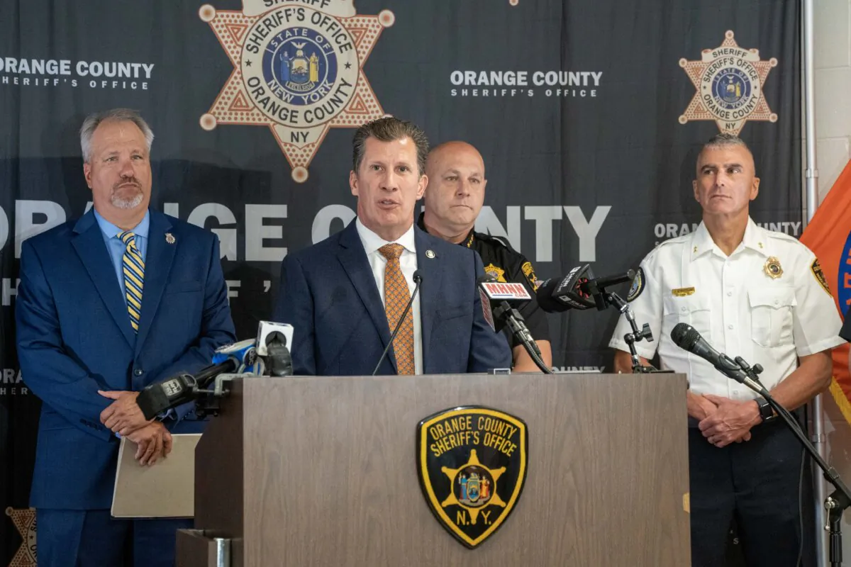 ATF New York Field Division Special Agent Bryan Miller (C), flanked by Orange County District Attorney David Hoovler (L) and Orange County Sheriff Paul Arteta (R), speaks at a press conference about Operation Hot Lunch in Goshen, N.Y., on May 29, 2024. (Cara Ding/The Epoch Times)