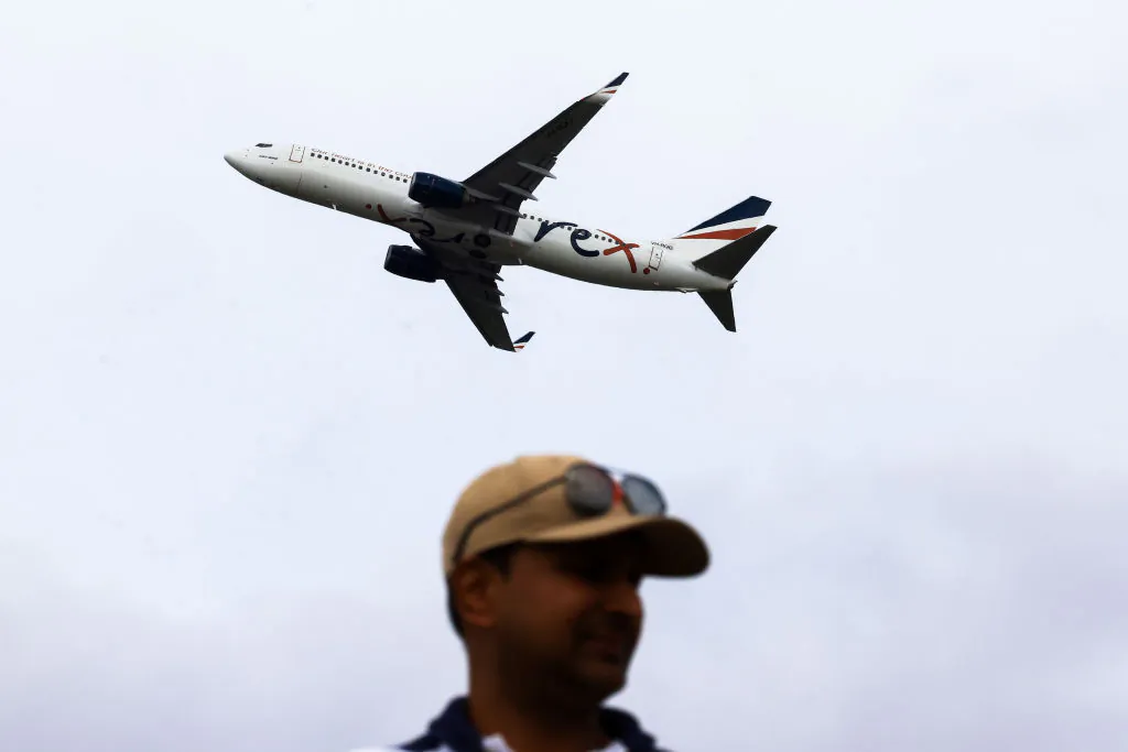 A man looks on as a Rex plane takes off from Sydney Airport in Sydney, Australia, on Jan. 20, 2024. (Jenny Evans/Getty Images)