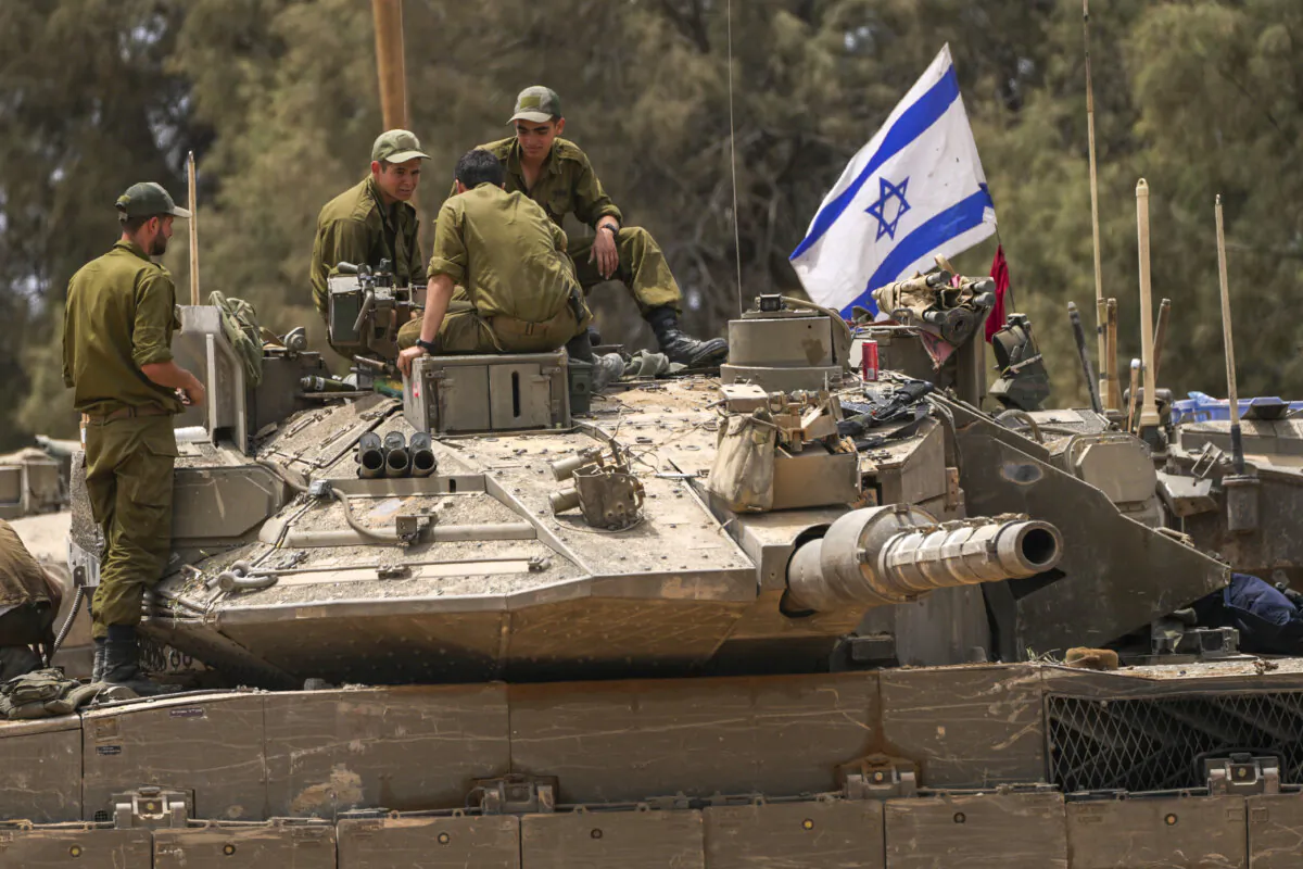 Israeli soldiers work on a tank near the Israeli-Gaza border in southern Israel on May 29, 2024. (Tsafrir Abayov/AP Photo)