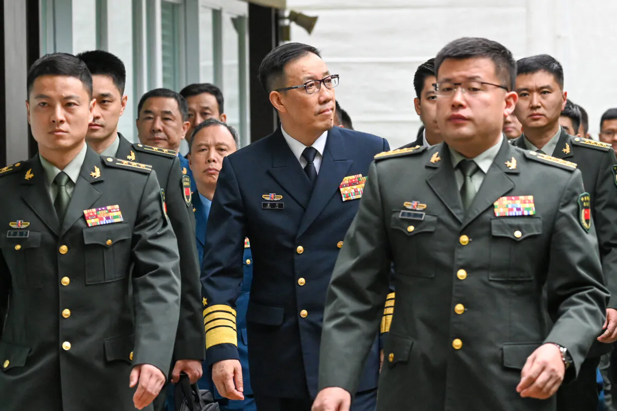 China's Defense Minister Adm. Dong Jun (C) arrives with his delegation for a bilateral meeting with U.S. Secretary of Defense Lloyd Austin on the sidelines of the 21st Shangri-La Dialogue summit at the Shangri-La Hotel in Singapore on May 31, 2024. (Roslan Rahman/AFP via Getty Images)