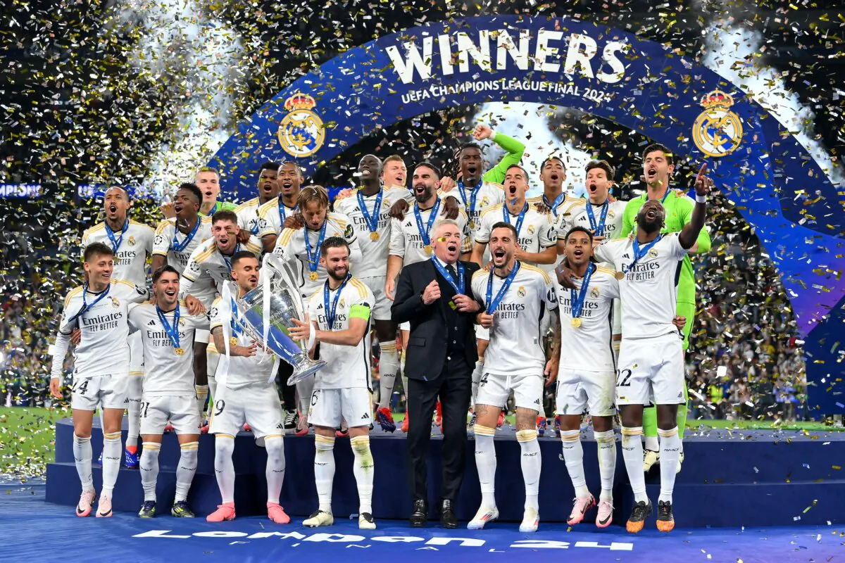 Nacho Fernandez of Real Madrid hands the UEFA Champions League Trophy to teammate Dani Ceballos during the UEFA Champions League 2023/24 Final match between Borussia Dortmund and Real Madrid CF at Wembley Stadium in London on June 1, 2024. (Justin Setterfield/Getty Images)